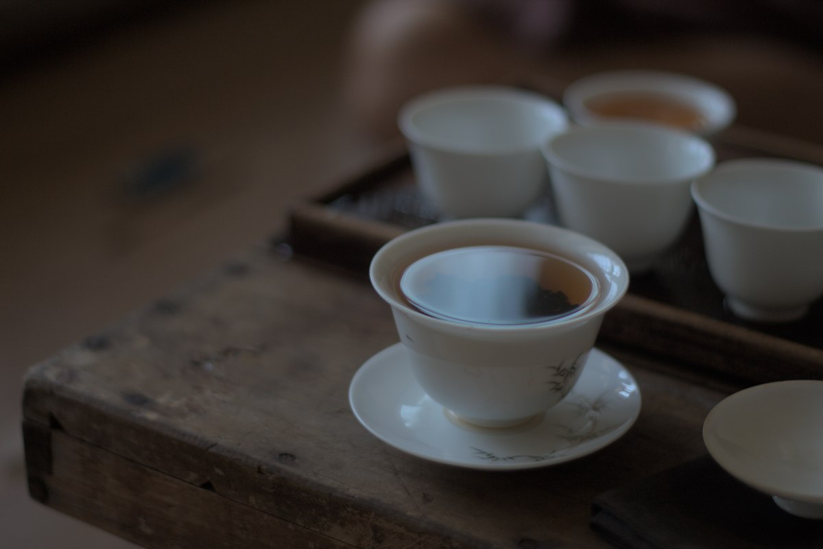 porcelain tea ware on wooden table filled with wild farmed loose leaf tea