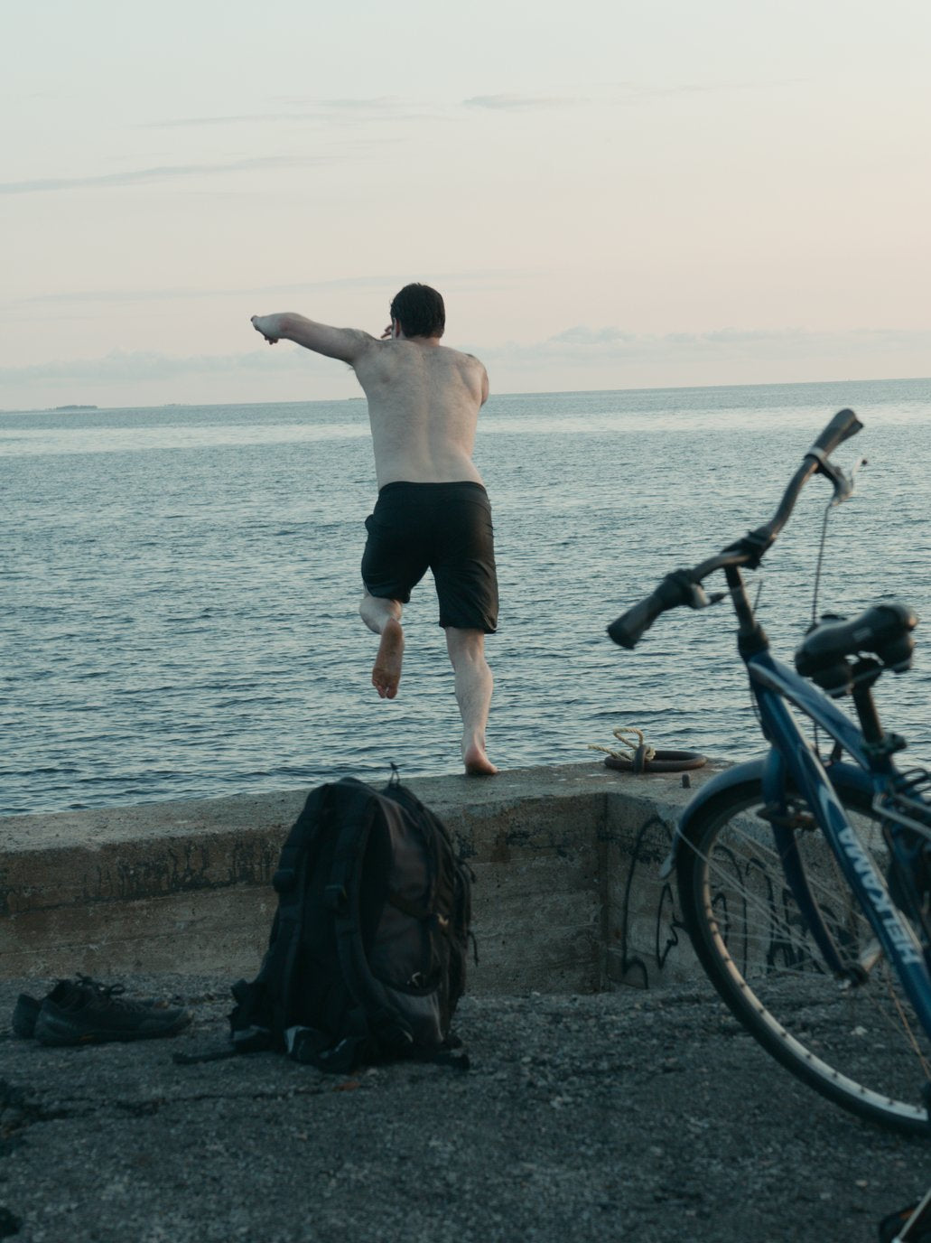 boy jumping into baltic sea during midnight sun near Oulu Finland