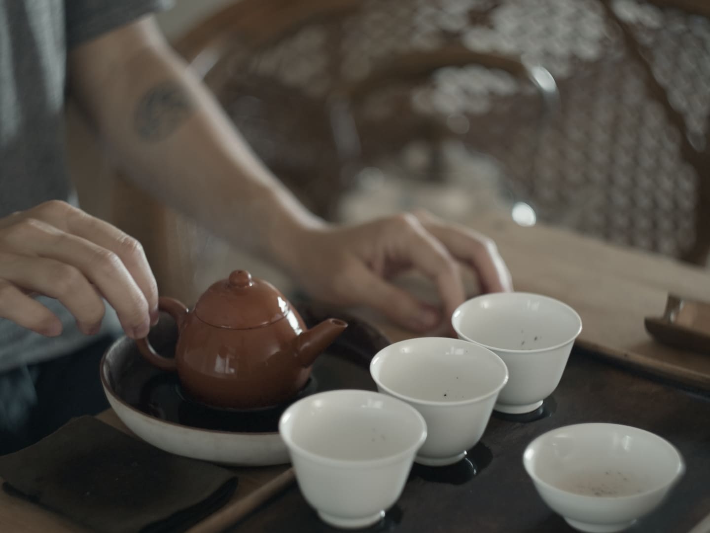 close-up tea ware and tea master brewing Gongfu tea