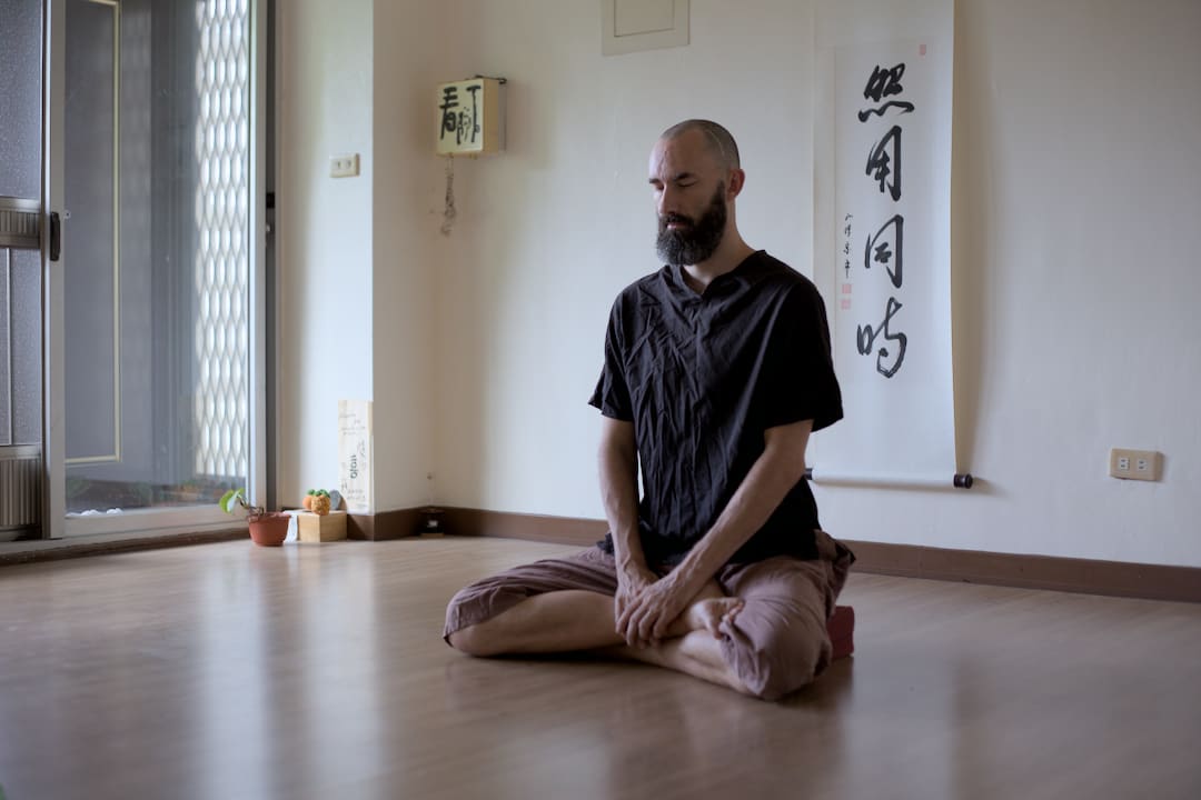 man sitting in meditation posture zazen in tea room