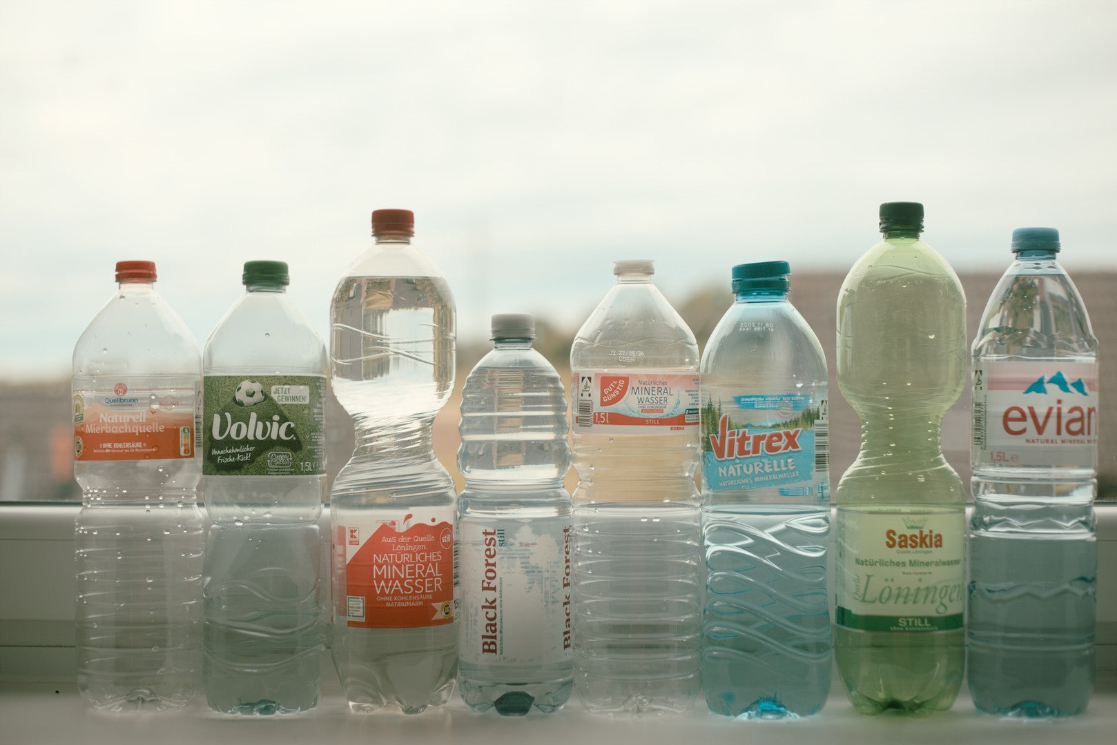 a row of different mineral water bottles for brewing wild farmed tea