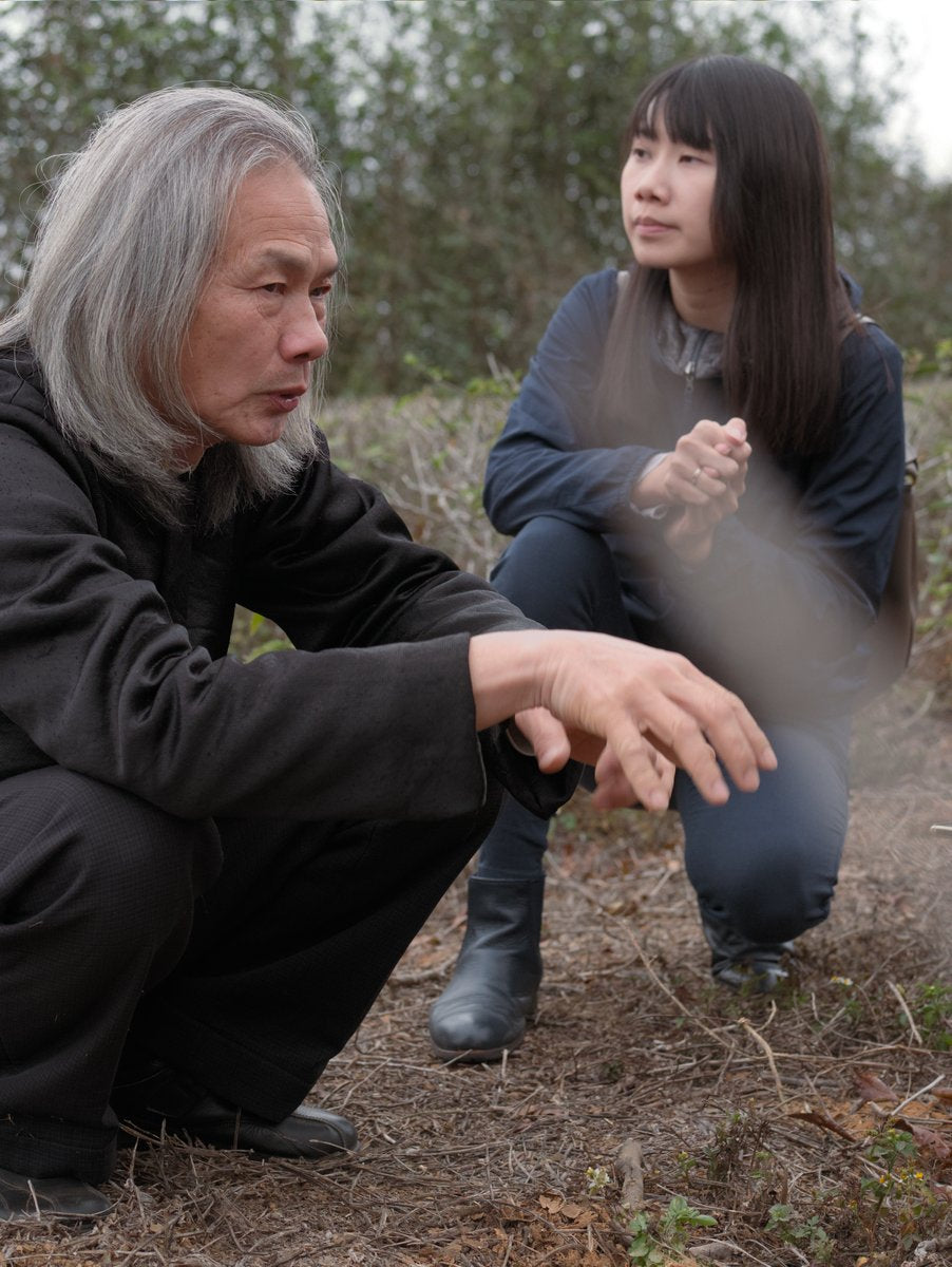 natural tea farmer sitting in his wild tea garden with his daughter