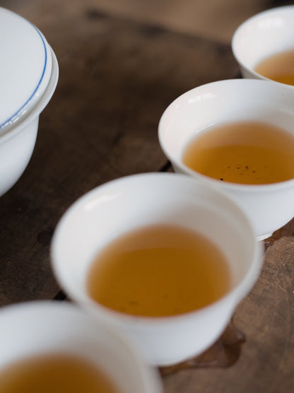 white porcelain cups on wooden board filled with naturally farmed oolong tea