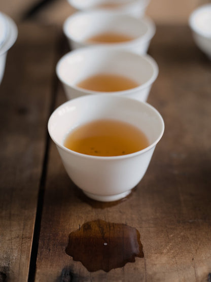 white porcelain cups on wooden board filled with naturally farmed oolong tea