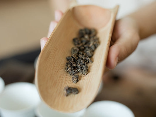 naturally farmed oolong tea on wooden scoop