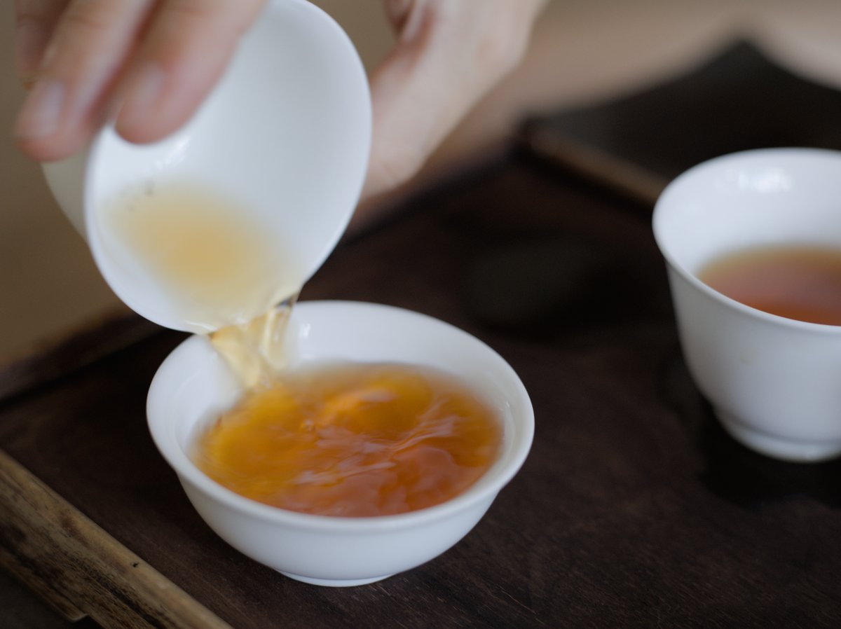 pouring naturally farmed Ruby Red Jade black tea into a white porcelain cup