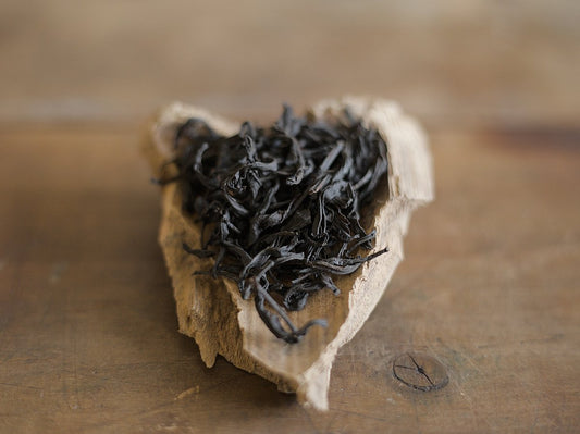 naturally farmed Ruby Red Jade black tea strips on a wooden scoop