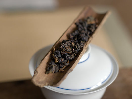 naturally farmed Tieguanyin oolong tea on a wooden scoop